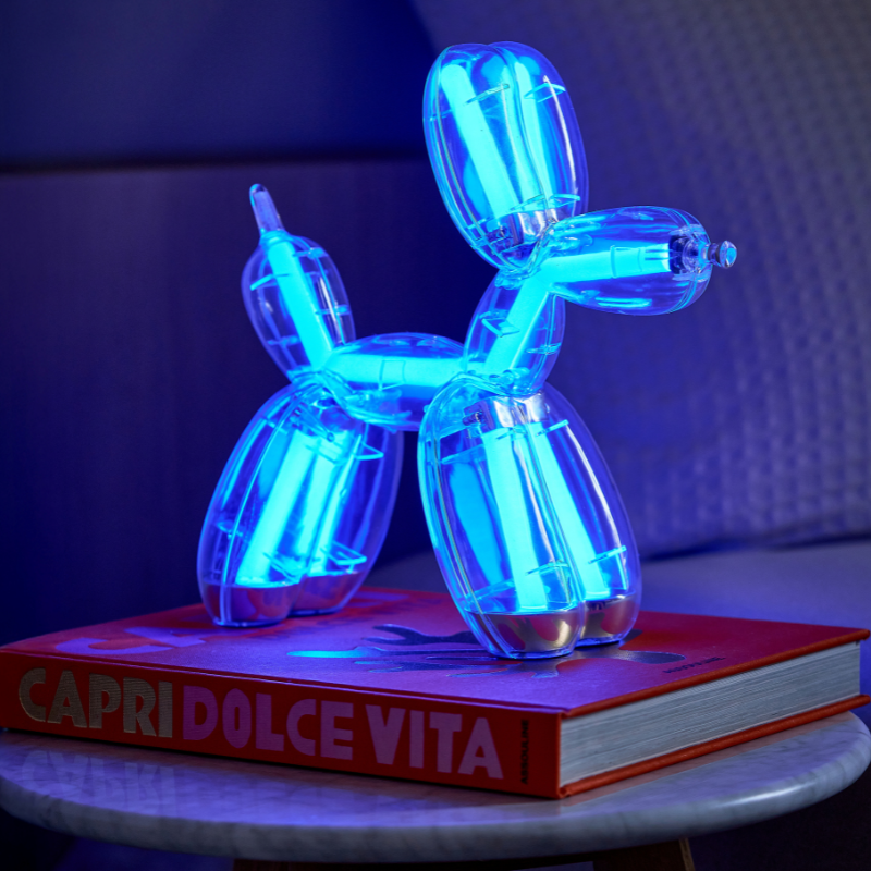 Lexon BALLOON DOG LAMP LED asztali lámpa, kék fénnyel egy dohányzóasztalon