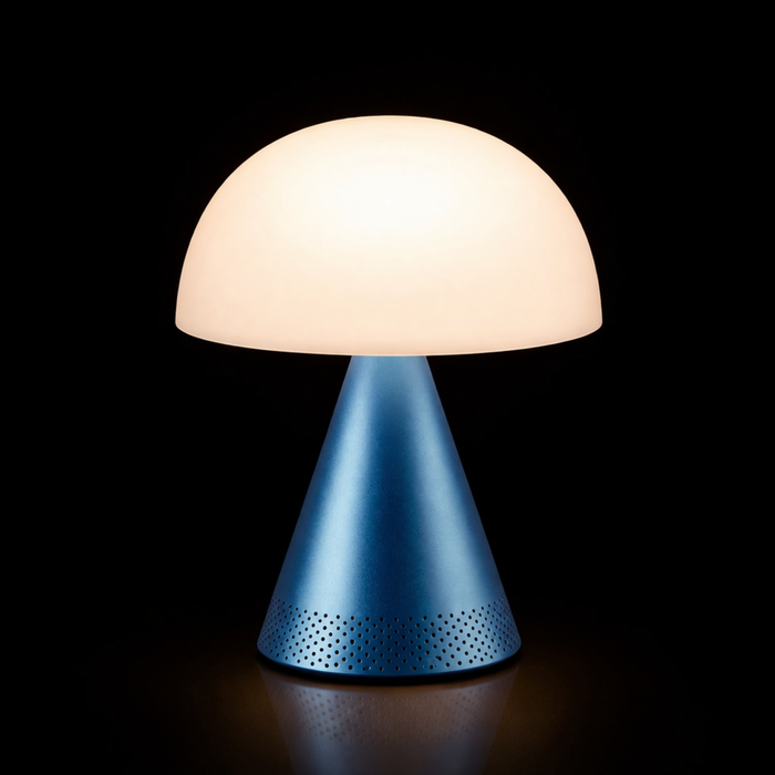 Lexon MINA L AUDIO hordozható LED asztali lámpa Bluetooth hangszóróval, kék talppal és bekapcsolt fehér fénnyel